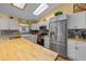Bright kitchen with white cabinets, stainless steel appliances and butcher block countertops at 408 Etheredge St, Bushnell, FL 33513