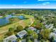 Aerial view showcasing the community with serene lake, lush golf course, and charming residential buildings at 450 Fairways Cir # A101, Ocala, FL 34472