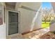Exterior view of a unit entrance with a screen door, small welcome mat, and view of greenery at 450 Fairways Cir # A101, Ocala, FL 34472