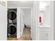 Hallway featuring stacked washer/dryer and open door to bedroom and bathroom at 450 Fairways Cir # A101, Ocala, FL 34472