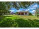 Spacious backyard with lush green lawn, mature trees, and a pergola-covered patio at 4735 Se 35Th St, Ocala, FL 34480