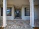 Covered porch with stone flooring and decorative front door with sidelights at 4735 Se 35Th St, Ocala, FL 34480