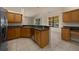 Open kitchen area with wood cabinets, tile flooring, stainless steel appliances, and breakfast bar at 4735 Se 35Th St, Ocala, FL 34480
