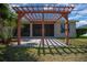 Pergola patio in backyard with brick pavers and lush green lawn at 4735 Se 35Th St, Ocala, FL 34480
