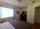 Bright bedroom with wood floors, large window, and dresser with mounted television at 6239 Sw 98Th Loop, Ocala, FL 34476