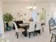 Elegant dining room featuring a modern chandelier, tile floors, and an adjacent doorway at 6239 Sw 98Th Loop, Ocala, FL 34476