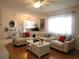 Inviting living room with large sofa, wood floors, and natural light from a large window at 6239 Sw 98Th Loop, Ocala, FL 34476