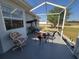 Screened-in patio featuring a patio swing, table, and chairs, perfect for outdoor relaxation at 6239 Sw 98Th Loop, Ocala, FL 34476