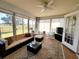 Sunroom with couch, table and chairs, and view of the lush backyard at 6239 Sw 98Th Loop, Ocala, FL 34476