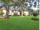 Exterior shot showcasing the manicured lawn and mature trees surrounding the multi-Gathering unit at 700 Midway Dr # B, Ocala, FL 34472