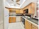 Practical kitchen layout with wooden cabinetry, white appliances, and a tile floor at 700 Midway Dr # B, Ocala, FL 34472