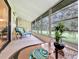 A relaxing sunroom features ample windows, a comfortable seating area, and views of the green golf course at 700 Midway Dr # B, Ocala, FL 34472