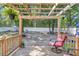 Backyard deck with hanging plants, wood pergola, and swivel chairs at 72 Dogwood Loop, Ocala, FL 34472