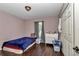 A basic bedroom featuring a twin bed, light pink walls, laminate flooring, and ample storage at 72 Dogwood Loop, Ocala, FL 34472