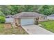 Home exterior featuring a two-car garage, neutral paint, and a well-maintained lawn with landscaped features at 72 Dogwood Loop, Ocala, FL 34472