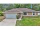 Charming single-story home featuring a well-maintained lawn, attached garage and beautiful landscape at 72 Dogwood Loop, Ocala, FL 34472