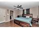 This main bedroom includes dark wooden floors, ceiling fan, a desk, and a door to the main bath at 72 Dogwood Loop, Ocala, FL 34472