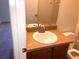 Bathroom sink with dark wood cabinet, white toilet, and mirror at 77 Dogwood Drive Pass, Ocala, FL 34472