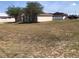 Traditional home featuring a large front yard with mature trees, a covered entryway, and a well-maintained exterior at 77 Dogwood Drive Pass, Ocala, FL 34472