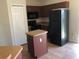 Compact kitchen featuring dark appliances, brown cabinets, and tile flooring at 77 Dogwood Drive Pass, Ocala, FL 34472
