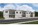 View of a modern multi-unit residential building with garages and neutral-toned facade against a cloudy sky at 8413 Gower Trl, Wildwood, FL 34785