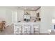 A modern kitchen featuring white cabinetry, stainless steel appliances, and bar seating and dining area at 8415 Gower Trl, Wildwood, FL 34785