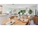 Bright dining room connected to a living area, featuring a wooden table, and modern decor at 8419 Gower Trl, Wildwood, FL 34785