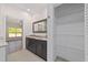 Bathroom featuring a double sink vanity, large mirror, and a linen closet at 8498 Sw 129Th Terrace Rd, Dunnellon, FL 34432