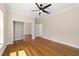 Bedroom features hardwood floors, a ceiling fan, and a mirrored closet door at 8498 Sw 129Th Terrace Rd, Dunnellon, FL 34432