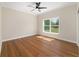 Bedroom featuring a ceiling fan, hardwood floors, and a large window providing natural light at 8498 Sw 129Th Terrace Rd, Dunnellon, FL 34432