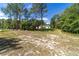 Exterior view of the home with a large front yard and a tree lined perimeter at 8498 Sw 129Th Terrace Rd, Dunnellon, FL 34432