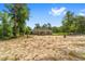 Exterior view of the home with a large front yard and a tree lined perimeter at 8498 Sw 129Th Terrace Rd, Dunnellon, FL 34432