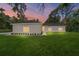 Charming single-story home with lush green lawn, landscaping, and a colorful sunset at 8498 Sw 129Th Terrace Rd, Dunnellon, FL 34432
