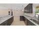 Bright kitchen features granite counters, stainless sink, tile floor and stylish modern lighting at 8498 Sw 129Th Terrace Rd, Dunnellon, FL 34432