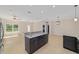 Kitchen with granite island, stainless steel fridge, open-plan living area, and modern fixtures at 8498 Sw 129Th Terrace Rd, Dunnellon, FL 34432