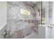 Walk-in shower featuring marble-like tile, a rain shower head and a glass door at 8498 Sw 129Th Terrace Rd, Dunnellon, FL 34432
