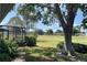 Backyard view featuring a screened patio overlooking a lush green lawn and a golf course, offering serene outdoor living at 9314 Sw 90Th St, Ocala, FL 34481