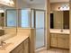 Bathroom featuring dual vanities, a glass-enclosed shower, and tiled floors, offering space and style at 9314 Sw 90Th St, Ocala, FL 34481