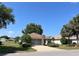Charming single-story home featuring a well-manicured lawn, mature trees, and a two-car garage at 9314 Sw 90Th St, Ocala, FL 34481