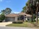 Charming single-story home featuring a manicured lawn, mature trees, and an attached two-car garage at 9314 Sw 90Th St, Ocala, FL 34481