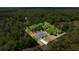 Aerial perspective displays a home with a screened pool, complemented by expansive greenery and mature trees at 9835 Sw 207Th Cir, Dunnellon, FL 34431
