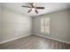 Cozy bedroom showcasing wood-look floors, neutral paint, and shuttered window at 9835 Sw 207Th Cir, Dunnellon, FL 34431