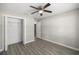 Empty bedroom boasts modern gray flooring, a ceiling fan, and a closet at 9835 Sw 207Th Cir, Dunnellon, FL 34431