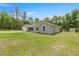 Side view of a well-maintained home featuring a lush lawn and a storage shed in the backyard at 9835 Sw 207Th Cir, Dunnellon, FL 34431