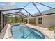 View of the screened-in pool with hot tub and outdoor entertainment area at 9835 Sw 207Th Cir, Dunnellon, FL 34431