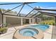 Relaxing screened-in pool and hot tub with a view of the backyard at 9835 Sw 207Th Cir, Dunnellon, FL 34431