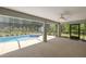 Screened-in pool area with hot tub, ceiling fan, and view of the lush landscaping at 9835 Sw 207Th Cir, Dunnellon, FL 34431