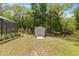 Backyard shed on a grassy lawn with surrounding trees at 9835 Sw 207Th Cir, Dunnellon, FL 34431