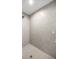 Modern shower featuring gray tile surround and floor, as well as updated fixtures at 9835 Sw 207Th Cir, Dunnellon, FL 34431