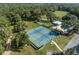 Aerial view of well-maintained tennis courts, pool, and nearby clubhouse amenities at 9835 Sw 207Th Cir, Dunnellon, FL 34431